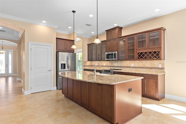 kitchen with visible vents, arched walkways, appliances with stainless steel finishes, ornamental molding, and backsplash