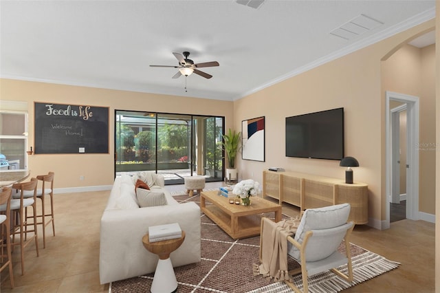 tiled living area featuring arched walkways, ceiling fan, visible vents, baseboards, and ornamental molding