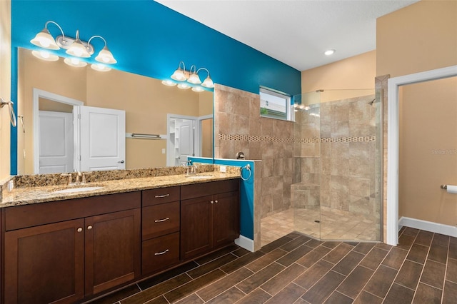 bathroom with double vanity, a sink, and walk in shower