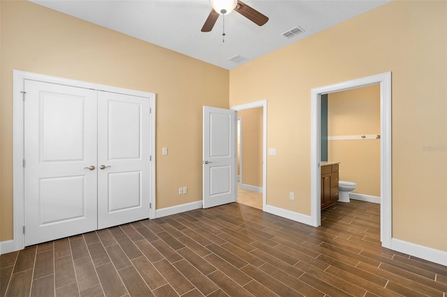 unfurnished bedroom featuring a closet, visible vents, ensuite bathroom, wood tiled floor, and baseboards