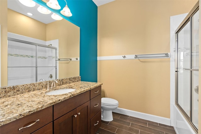 bathroom featuring toilet, wood tiled floor, vanity, and baseboards