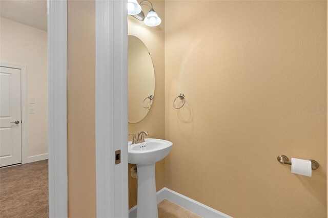 bathroom featuring a sink and baseboards