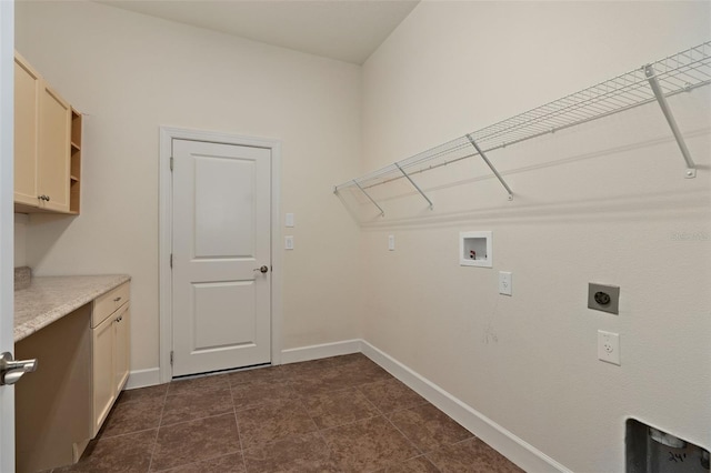 clothes washing area featuring cabinet space, baseboards, dark tile patterned flooring, hookup for a washing machine, and electric dryer hookup