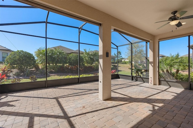 unfurnished sunroom featuring a ceiling fan