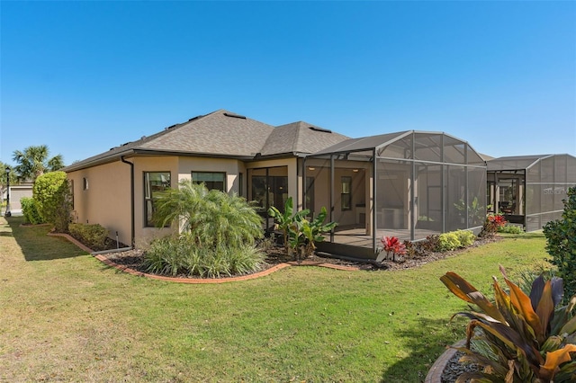 rear view of property with a lawn, a lanai, and stucco siding