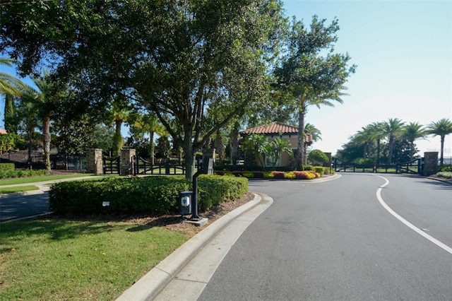 view of street with curbs and a gated entry