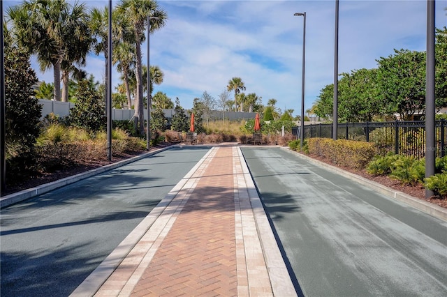 view of road featuring street lighting and curbs