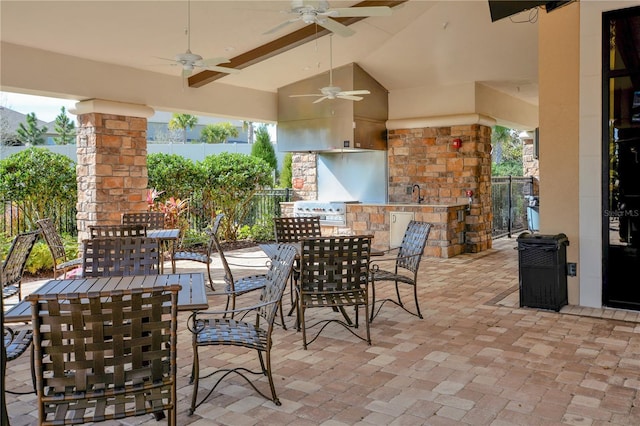 view of patio featuring a sink, outdoor dining space, fence, and a grill