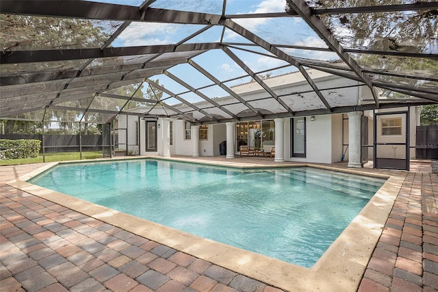 view of swimming pool with a fenced in pool, glass enclosure, a patio, and fence