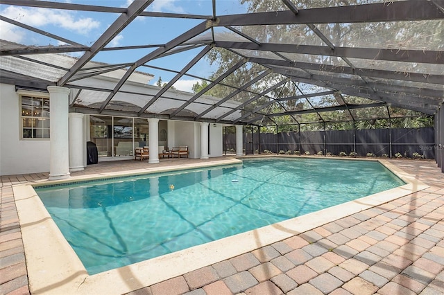 view of swimming pool with a fenced in pool, glass enclosure, a patio area, and fence