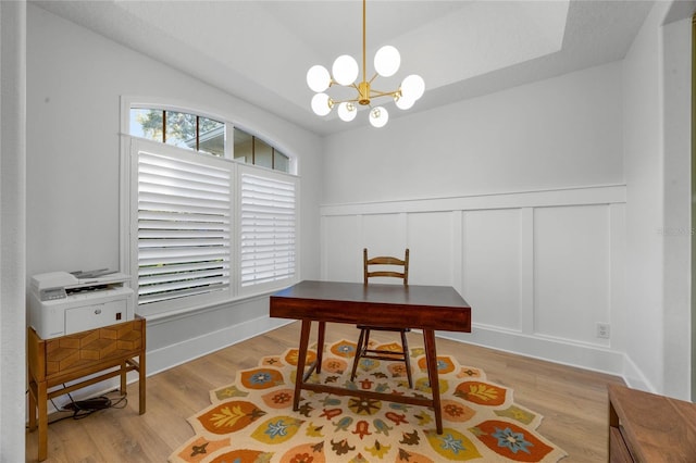 office with a notable chandelier, wainscoting, a decorative wall, and wood finished floors