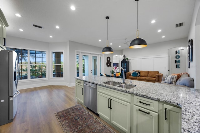 kitchen with visible vents, open floor plan, appliances with stainless steel finishes, wood finished floors, and a sink