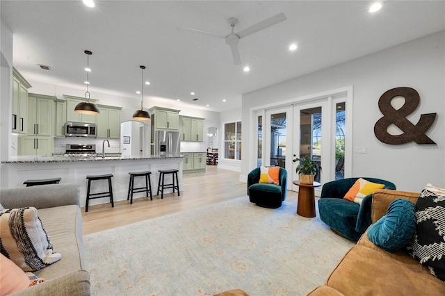 living room featuring visible vents, light wood-style flooring, recessed lighting, french doors, and ceiling fan