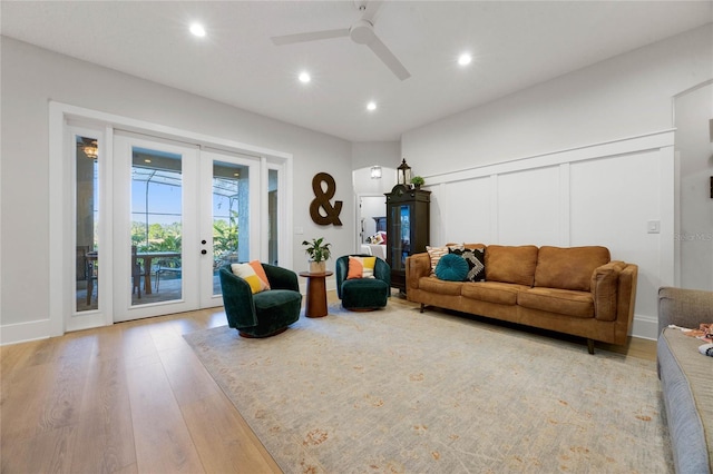 living area featuring a decorative wall, recessed lighting, french doors, and light wood-style floors