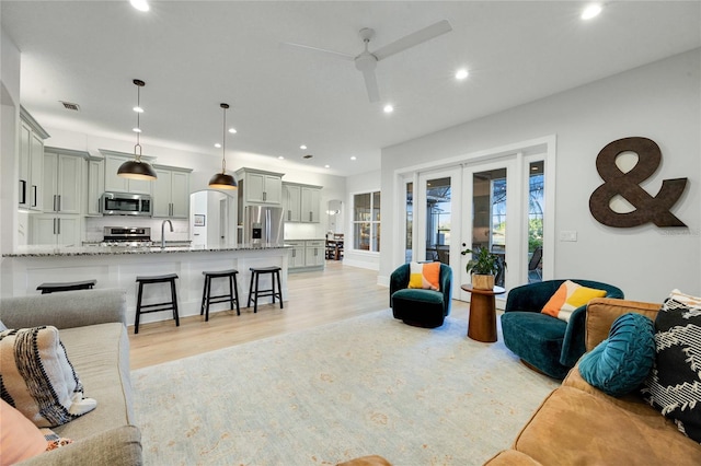 living area featuring visible vents, recessed lighting, ceiling fan, light wood-style floors, and french doors