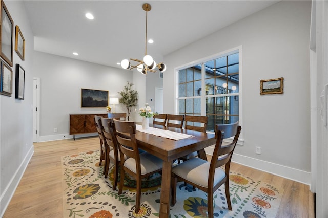 dining space featuring light wood-style flooring, a notable chandelier, recessed lighting, and baseboards