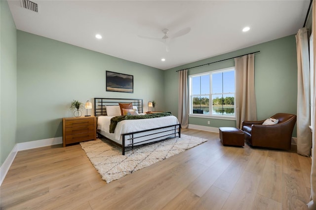 bedroom with visible vents, light wood-style flooring, and baseboards