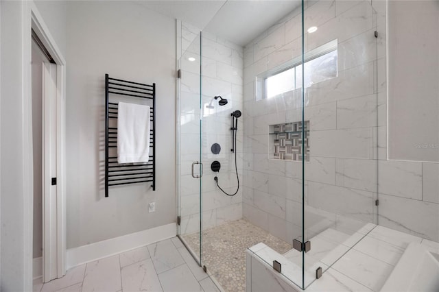 full bath featuring radiator heating unit, baseboards, marble finish floor, and a stall shower