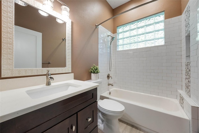 full bathroom with vanity, toilet, tub / shower combination, and a textured wall