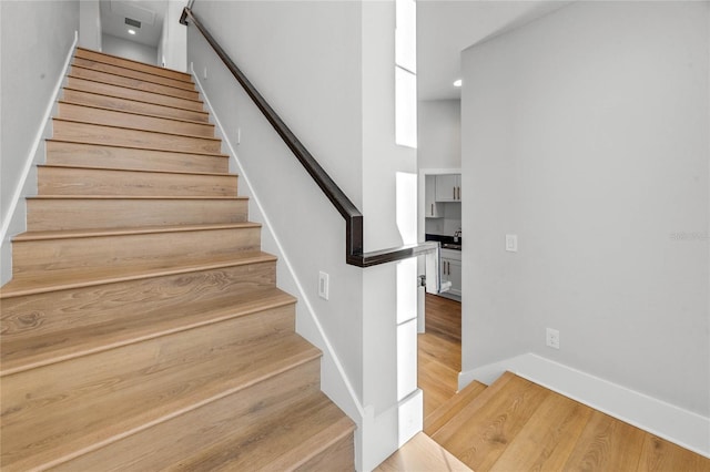 stairs featuring baseboards and wood finished floors