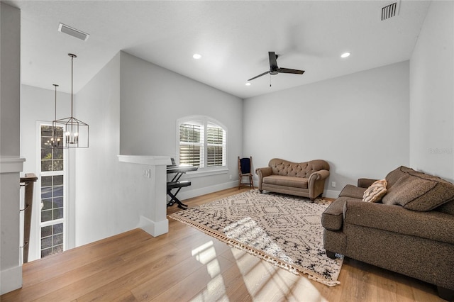 living area with recessed lighting, wood finished floors, visible vents, and baseboards