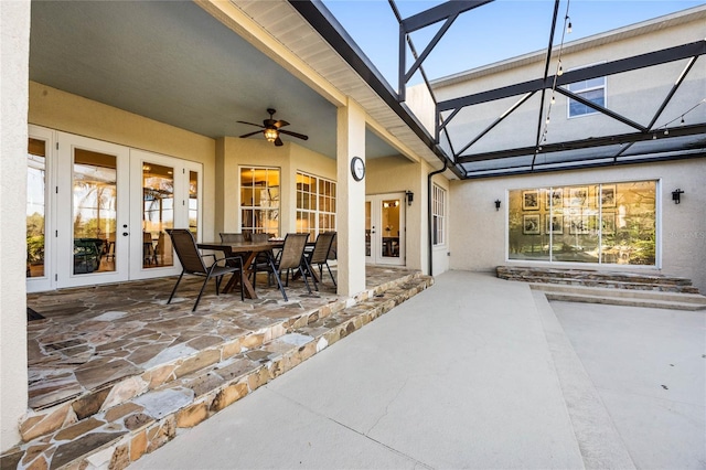 view of patio featuring french doors, a ceiling fan, and glass enclosure