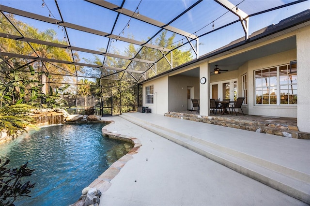 pool featuring glass enclosure, a patio area, and a ceiling fan