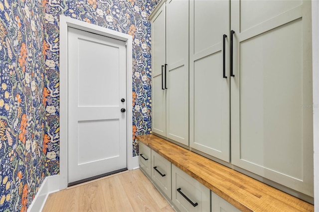 mudroom with wallpapered walls, baseboards, and light wood finished floors