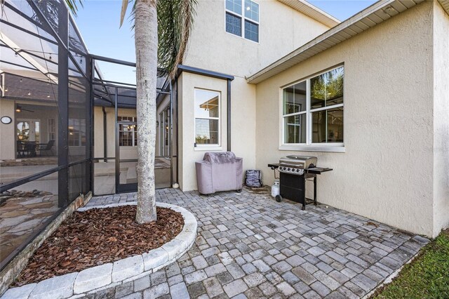 view of patio with grilling area and glass enclosure