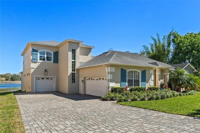 view of front facade with stucco siding and decorative driveway