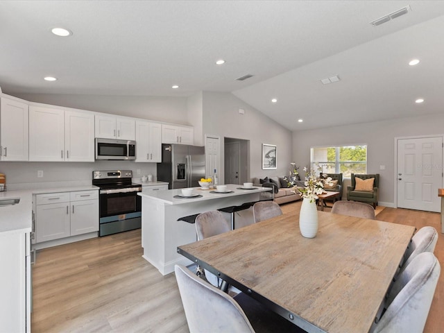 kitchen featuring a center island, stainless steel appliances, light countertops, visible vents, and white cabinets