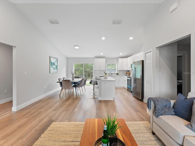 living room with light wood-style floors, recessed lighting, visible vents, and baseboards