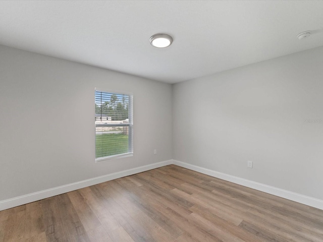 unfurnished room with light wood-style flooring and baseboards