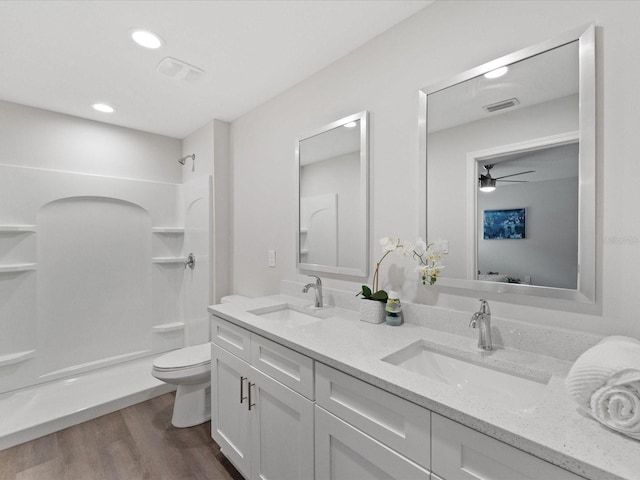 bathroom with toilet, visible vents, a sink, and wood finished floors