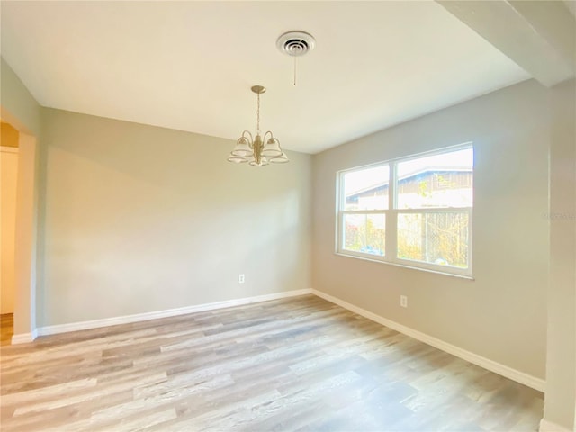 unfurnished room with light wood-style floors, baseboards, visible vents, and a chandelier