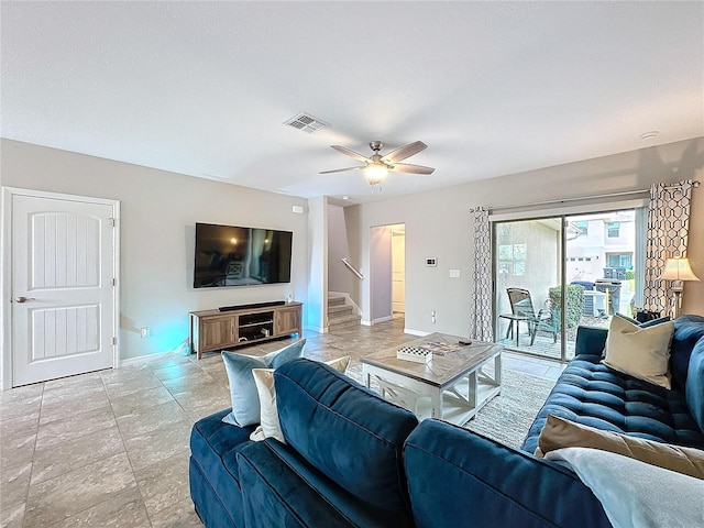 living area with a ceiling fan, visible vents, stairway, and baseboards