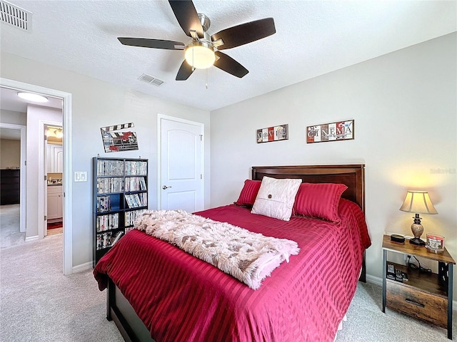 carpeted bedroom featuring visible vents, a textured ceiling, and baseboards