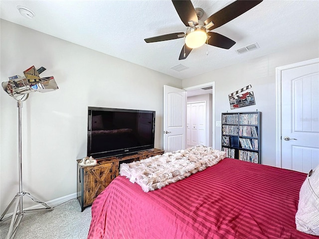 bedroom featuring a textured ceiling, carpet floors, visible vents, baseboards, and a ceiling fan