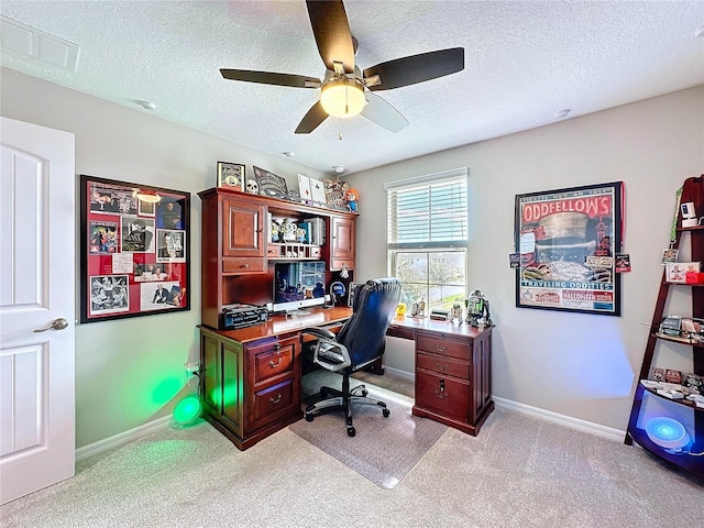 office featuring light colored carpet, visible vents, a textured ceiling, and baseboards