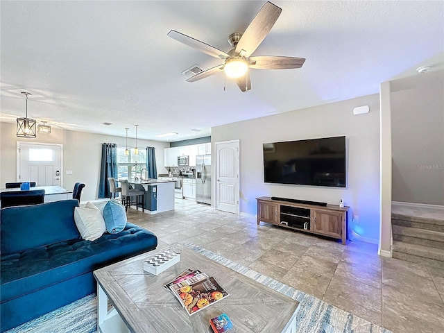 living room with stairway, plenty of natural light, visible vents, and baseboards