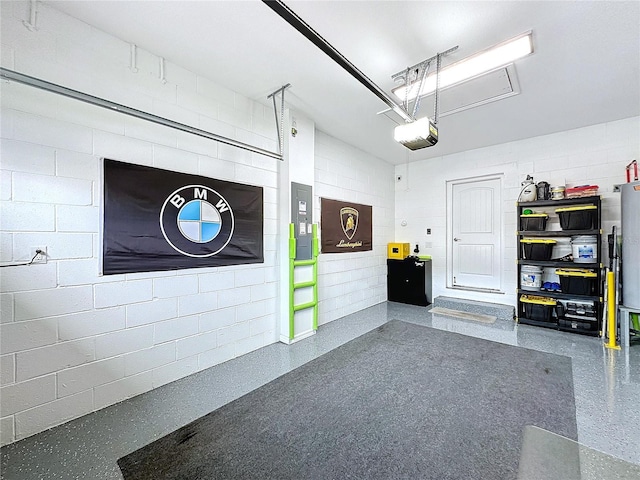 garage featuring concrete block wall and a garage door opener