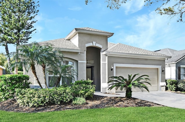 view of front of home featuring a garage, concrete driveway, roof with shingles, and stucco siding