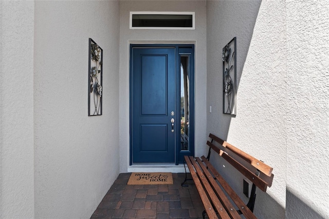 entrance to property featuring stucco siding