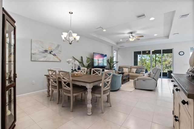 dining space with a tray ceiling, visible vents, and light tile patterned floors