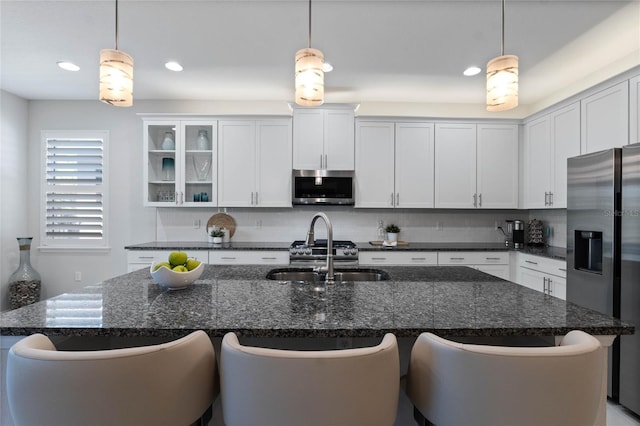 kitchen with a kitchen bar, appliances with stainless steel finishes, backsplash, and a sink