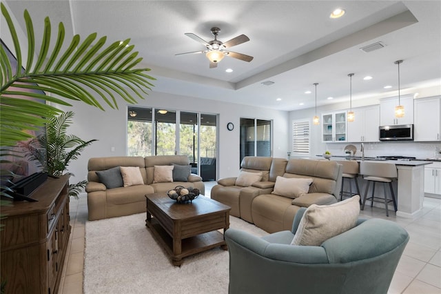 living room featuring recessed lighting, a raised ceiling, visible vents, and light tile patterned floors