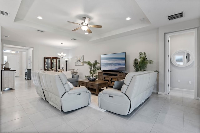 living area with visible vents and a tray ceiling