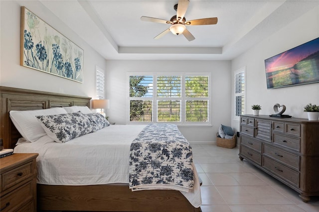 bedroom featuring multiple windows, a tray ceiling, and light tile patterned flooring