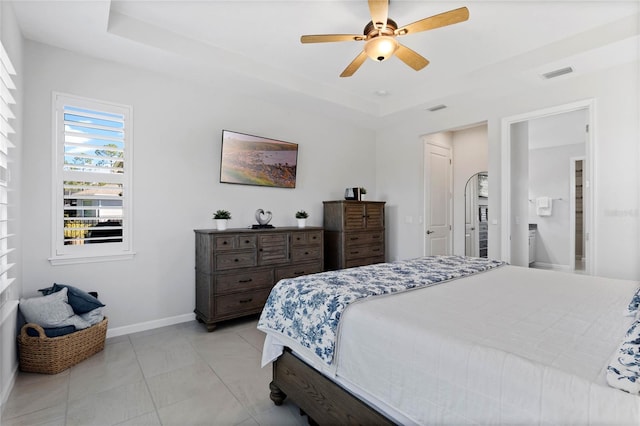 bedroom with light tile patterned floors, a raised ceiling, visible vents, ceiling fan, and baseboards