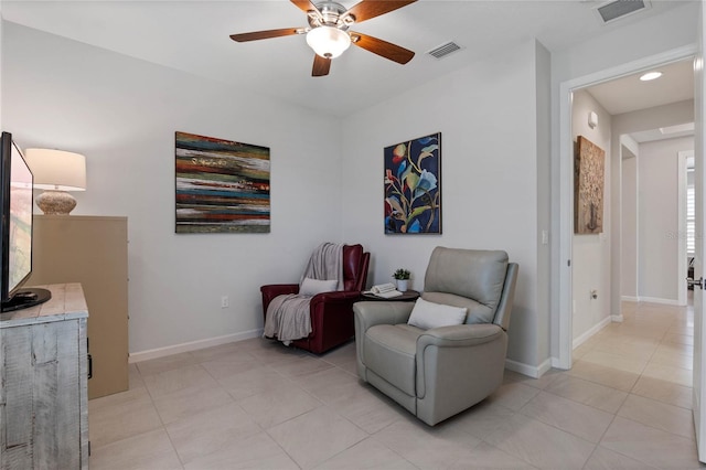 living area with light tile patterned floors, baseboards, visible vents, and a ceiling fan